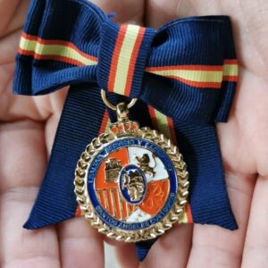 Medalla con lazo de dama sostenida entre las manos