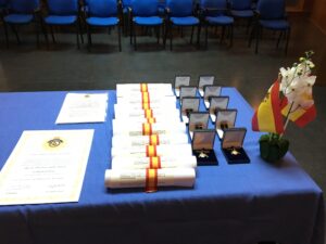 Mesa de acto con diplomas, condecoraciones y bandera española