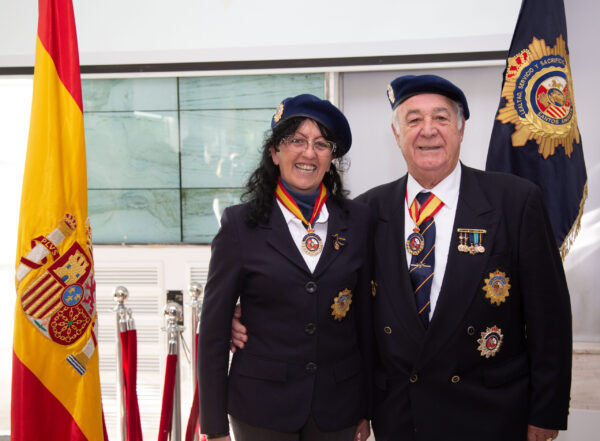 Socios con boina y blazer junto a la bandera de España